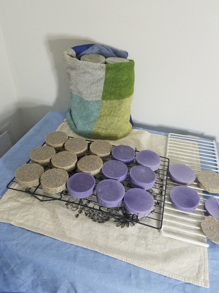 Soap molds wrapped in a bath towel and bars of soap curing.